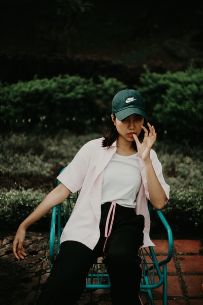坐着的女人穿着白衬衫和黑帽子